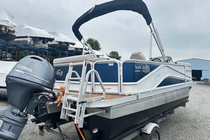 Slide: The Image of 2018 Yamaha Suncatcher G3 Pontoon boat with outboard motor, parked on gravel. - 1
