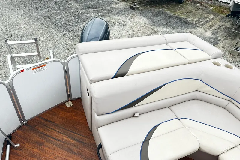 Slide: The Image of 2018 Yamaha Suncatcher G3 Pontoon with plush seating and outboard motor, docked on gravel. - 9