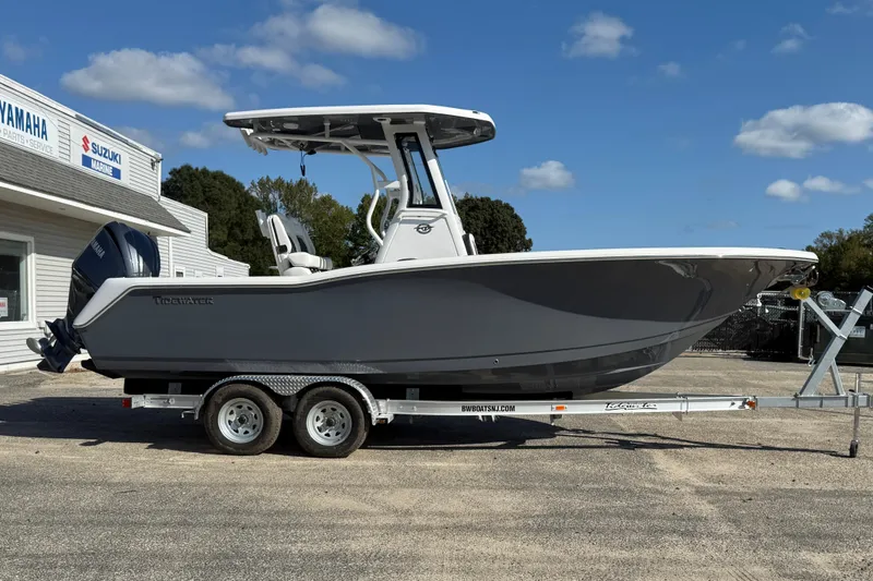 The Image of 2026 Tidewater 232 CC Adventure boat on trailer, parked outside marine service center. - 0