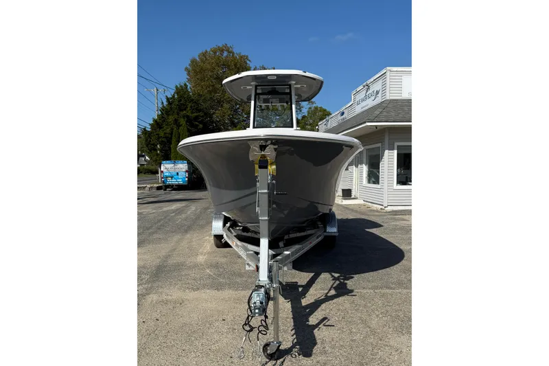 Slide: The Image of 2026 Tidewater 232 CC Adventure boat on trailer, parked outside a building. - 11