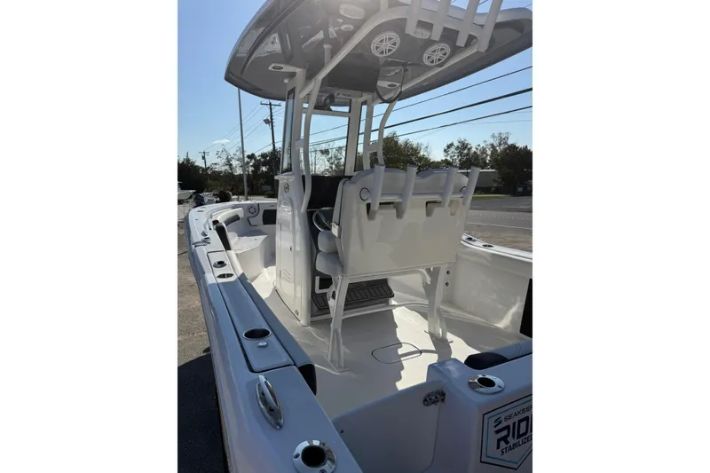 Slide: The Image of 2026 Tidewater 232 CC Adventure boat interior with seating and rod holders. - 13