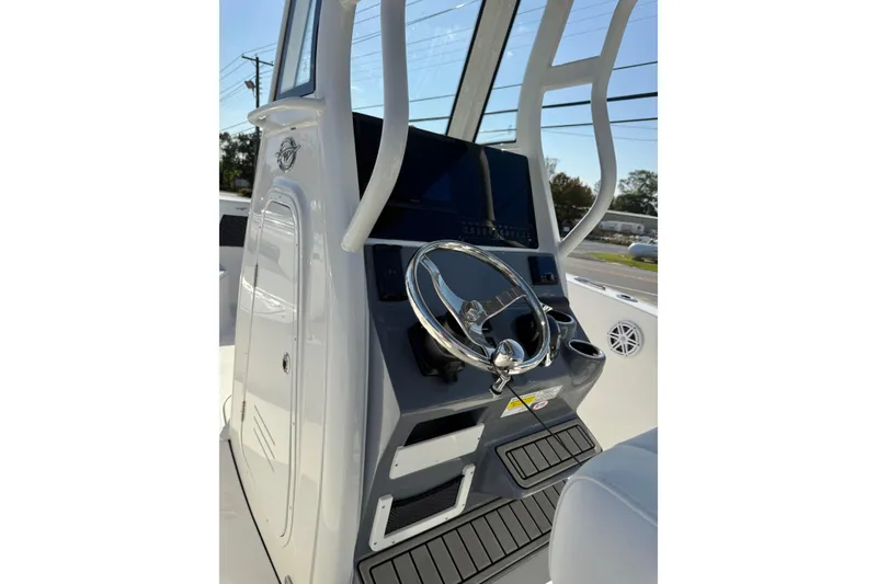 Slide: The Image of 2026 Tidewater 232 CC Adventure boat console with steering wheel and controls. - 14