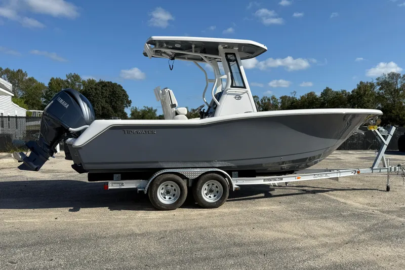 Slide: The Image of 2026 Tidewater 232 CC Adventure boat on trailer, side view, clear sky background. - 4