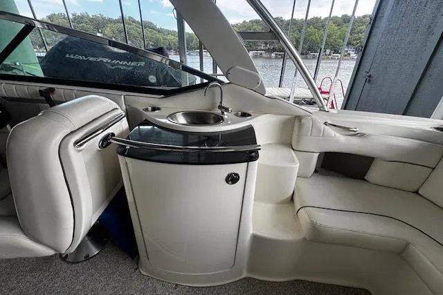 Slide: The Image of 2007 Sea Ray 270 SLX boat interior with sink and seating, docked by a lake. - 34