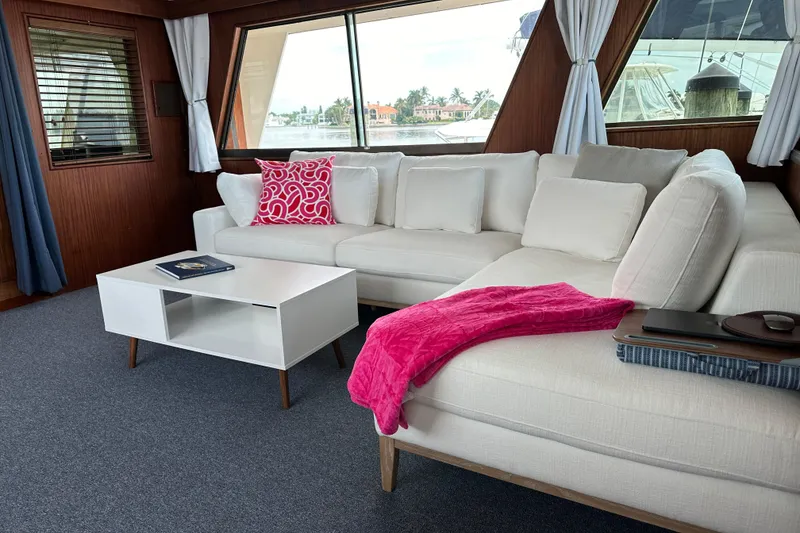 Slide: The Image of Luxurious interior of 1981 Hatteras 56 Motor Yacht with white sofa and vibrant decor. - 13