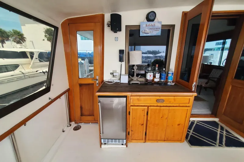 Slide: The Image of Interior of 1981 Hatteras 56 Motor Yacht with wooden cabinetry and mini fridge. - 17