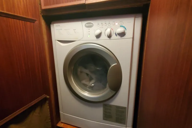 Slide: The Image of Washing machine inside 1981 Hatteras 56 Motor Yacht, surrounded by wooden cabinetry. - 18