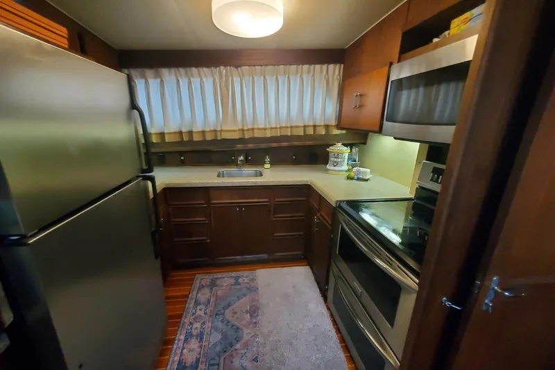 Slide: The Image of Cozy kitchen in 1981 Hatteras 56 Motor Yacht with modern appliances and wood cabinetry. - 19