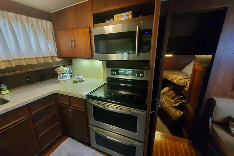 Slide: The Image of 1981 Hatteras 56 Motor Yacht kitchen with modern appliances and cozy cabin view. - 21