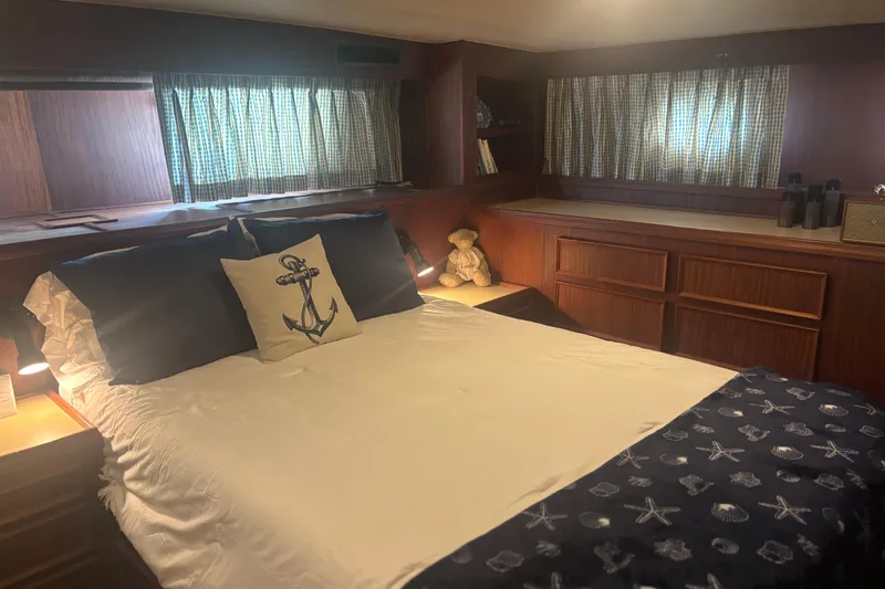 Slide: The Image of Cozy bedroom in 1981 Hatteras 56 Motor Yacht with nautical decor and wood paneling. - 23
