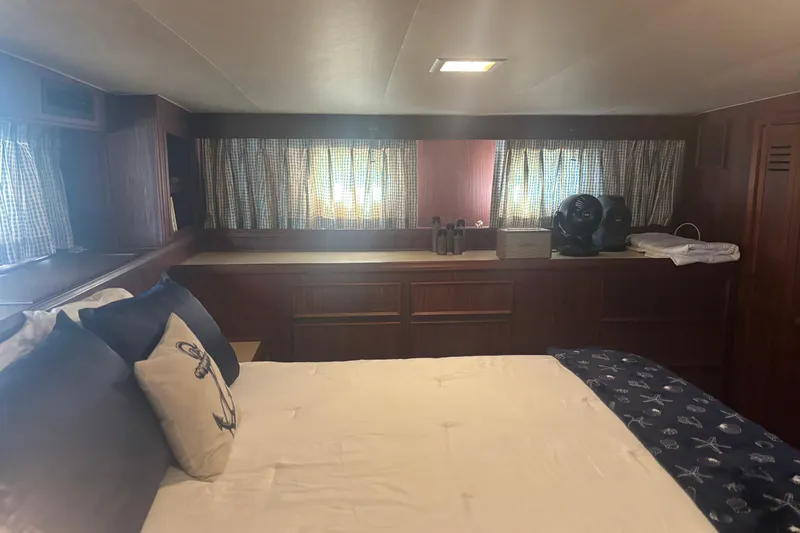 Slide: The Image of 1981 Hatteras 56 Motor Yacht bedroom with nautical decor and wooden cabinetry. - 24