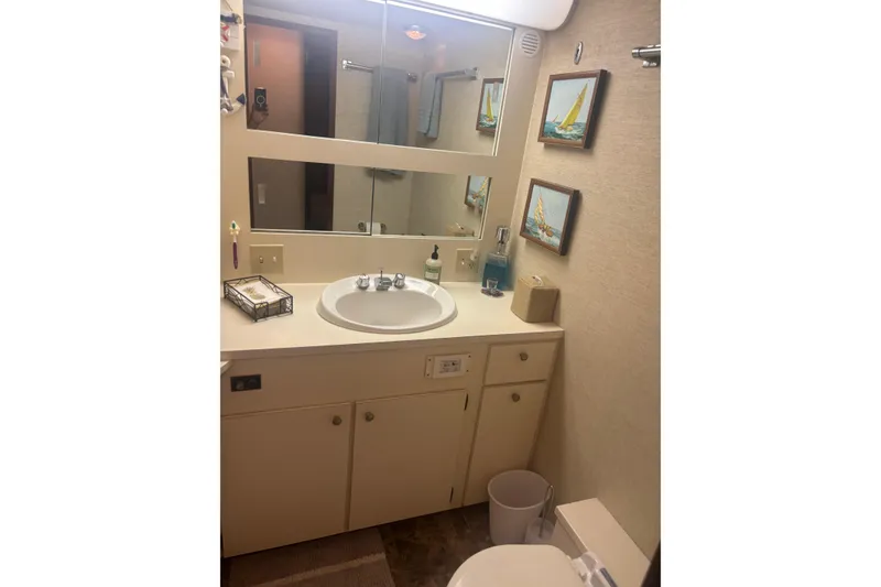 Slide: The Image of Bathroom interior of 1981 Hatteras 56 Motor Yacht with sink, mirror, and nautical decor. - 28