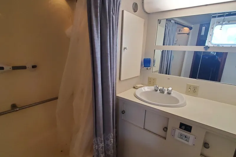 Slide: The Image of Bathroom interior of 1981 Hatteras 56 Motor Yacht with sink, mirror, and shower curtain. - 30
