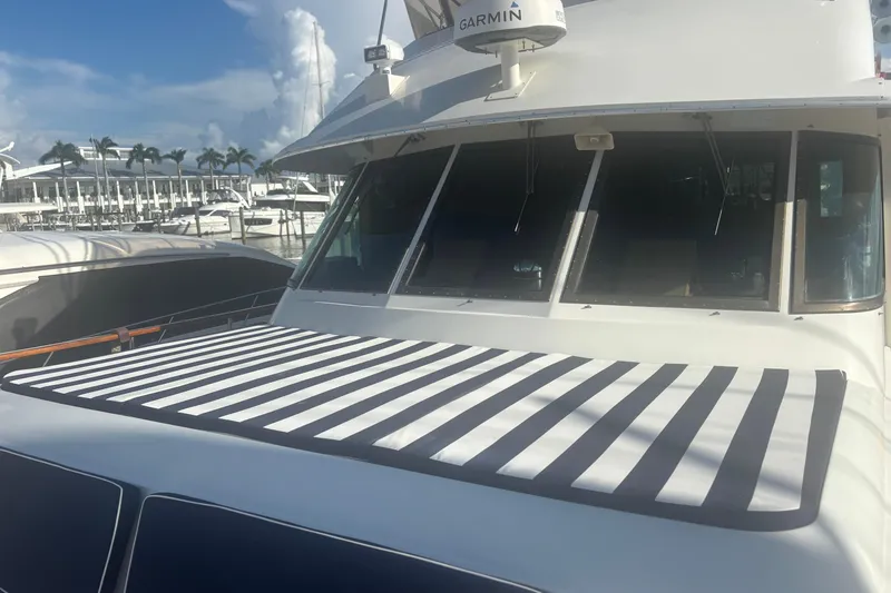 Slide: The Image of 1981 Hatteras 56 Motor Yacht with striped sunshade, docked at marina. - 5