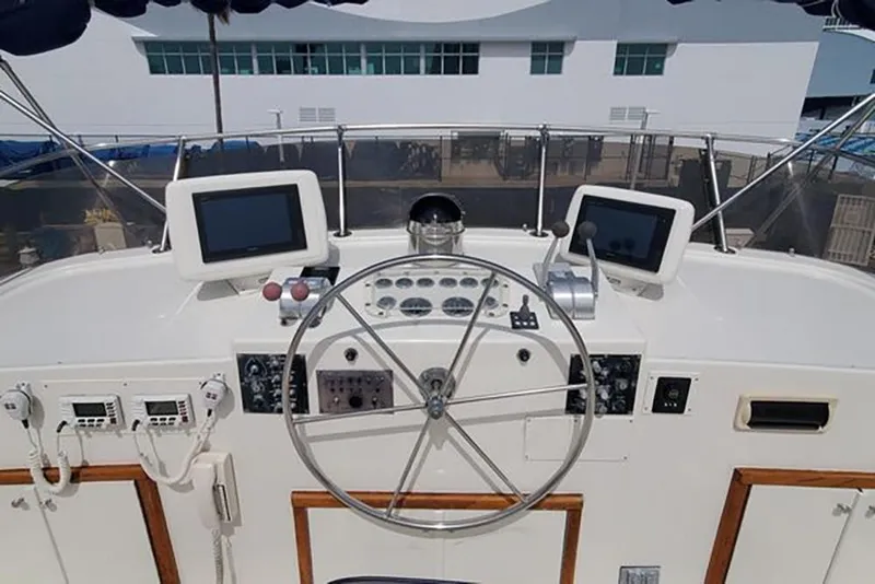 Slide: The Image of 1981 Hatteras 56 Motor Yacht helm with dual screens and classic steering wheel. - 6