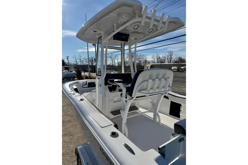 Slide: The Image of 2026 Tidewater 210 CC Adventure boat with T-top and seating, parked outdoors. - 10