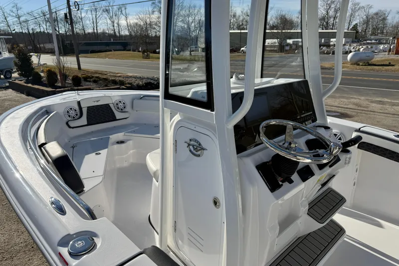 Slide: The Image of 2026 Tidewater 210 CC Adventure boat interior with steering console and seating area. - 16