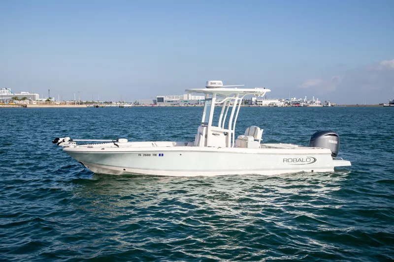 The Image of 2023 Robalo 246 Cayman boat on water, clear sky, industrial background. - 0