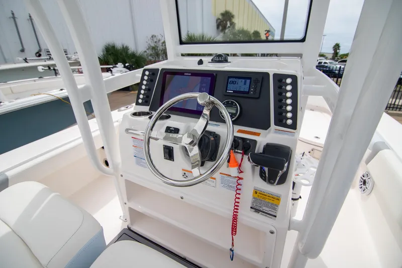 Slide: The Image of 2023 Robalo 246 Cayman boat dashboard with steering wheel and navigation controls. - 11