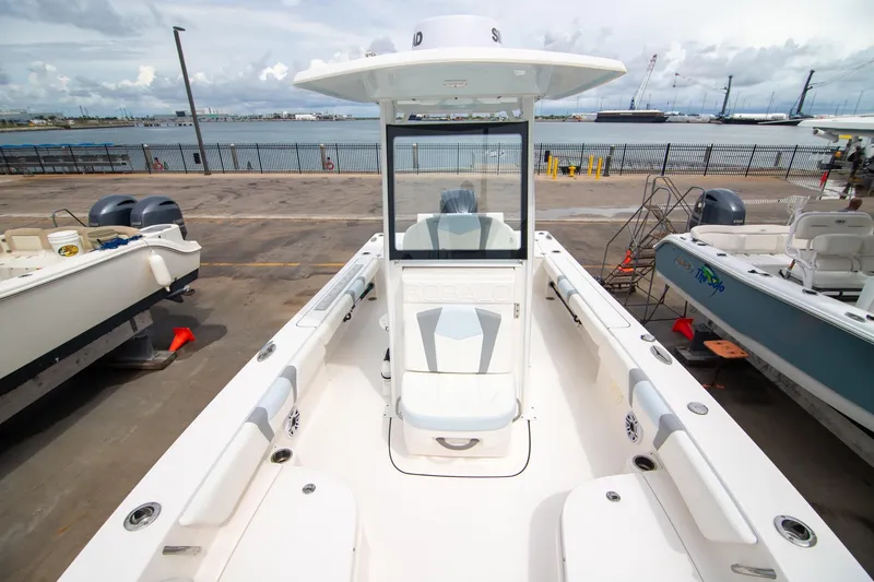 Slide: The Image of 2023 Robalo 246 Cayman boat docked, showcasing spacious deck and seating. - 12