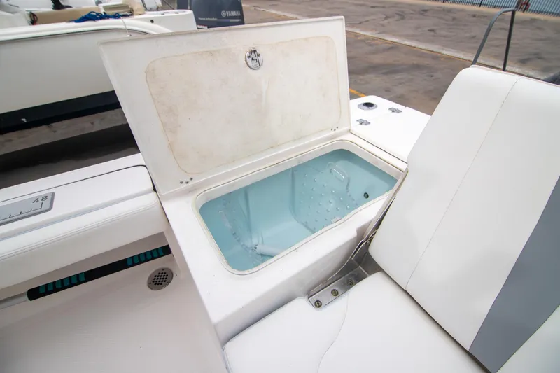 Slide: The Image of 2023 Robalo 246 Cayman boat with open storage compartment and seating area. - 16