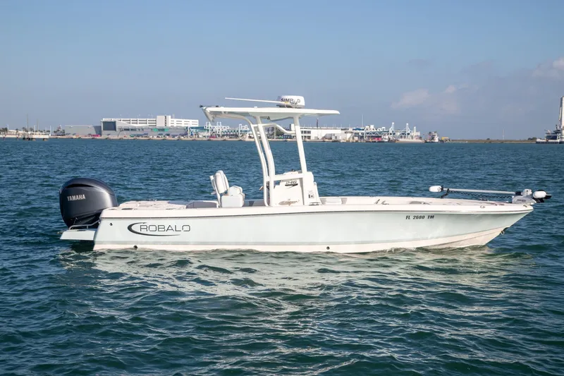 Slide: The Image of 2023 Robalo 246 Cayman boat on water with Yamaha engine, clear sky background. - 2