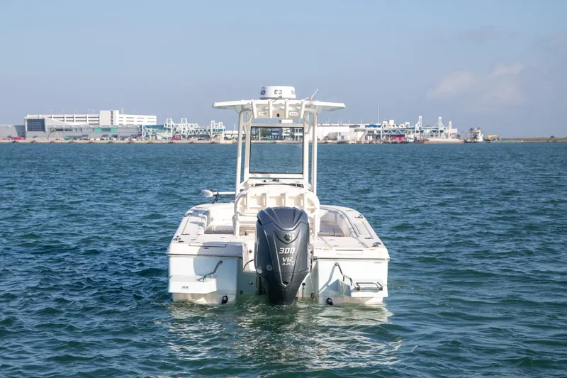 Slide: The Image of 2023 Robalo 246 Cayman boat on water, with cityscape in background. - 3