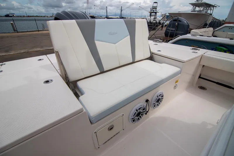 Slide: The Image of 2023 Robalo 246 Cayman boat interior with cushioned seating and built-in speakers. - 9