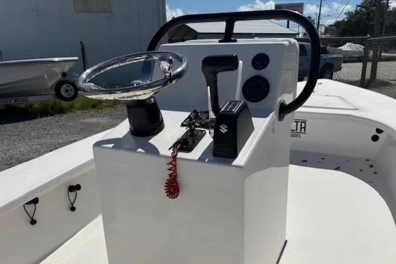 Slide: The Image of 2025 Delta Boatworks D18 console with steering wheel and controls, docked outdoors. - 4