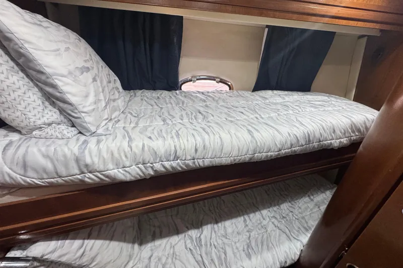 Slide: The Image of 1998 Carver 530 Voyager Pilothouse interior with cozy bunk beds and elegant wood finish. - 23