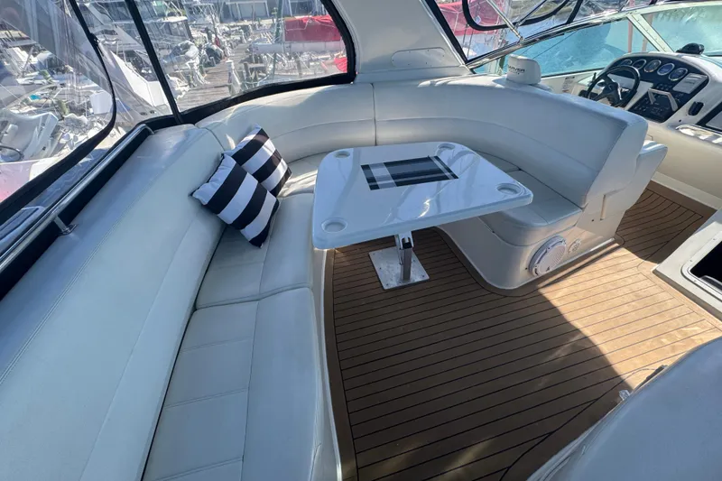 Slide: The Image of 1998 Carver 530 Voyager Pilothouse interior with white seating, striped pillows, and wooden flooring. - 40