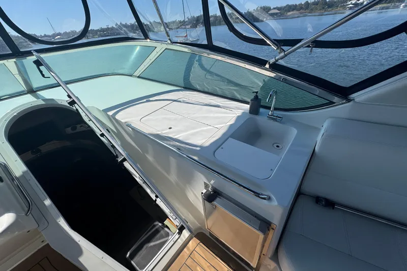 Slide: The Image of 1998 Carver 530 Voyager Pilothouse interior with sink and seating, overlooking water. - 48