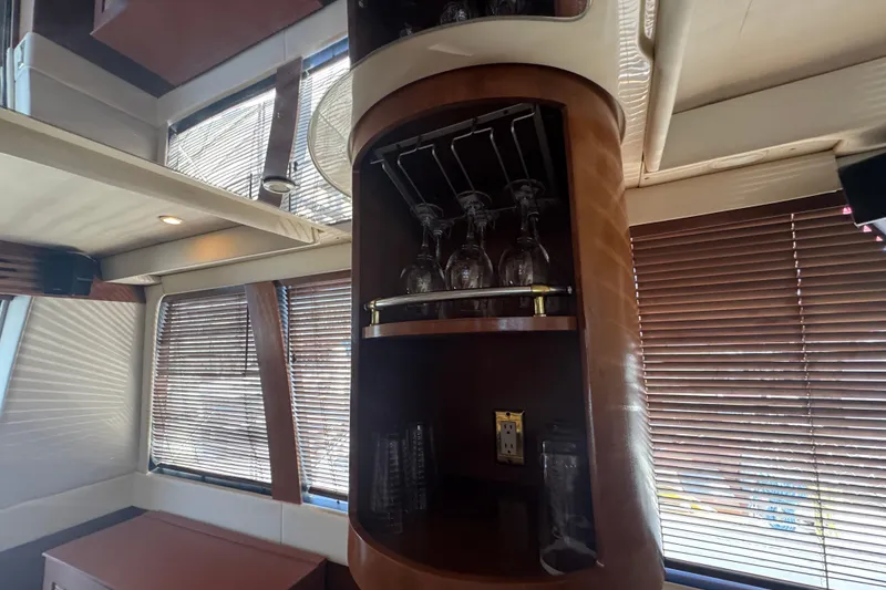 Slide: The Image of Interior of 1998 Carver 530 Voyager Pilothouse with glassware storage and wooden blinds. - 66