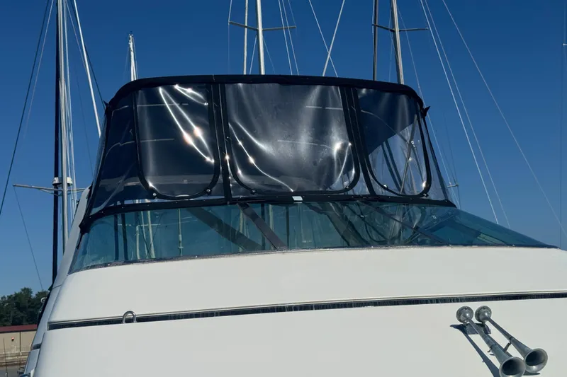 Slide: The Image of 1998 Carver 530 Voyager Pilothouse yacht with clear enclosure and blue sky background. - 81