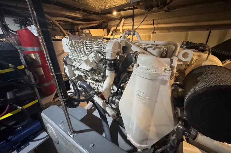 Slide: The Image of Engine room of 1998 Carver 530 Voyager Pilothouse with visible machinery and fire extinguisher. - 98