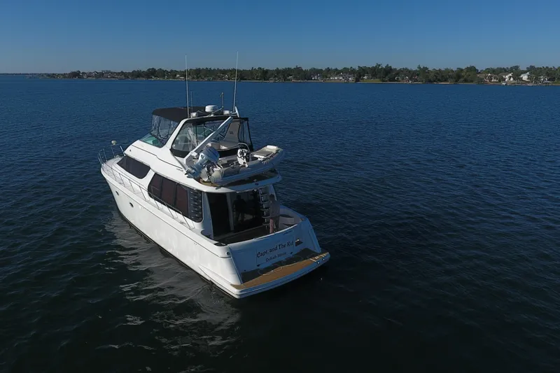 Slide: The Image of 1998 Carver 530 Voyager Pilothouse yacht cruising on calm waters under clear blue skies. - 107