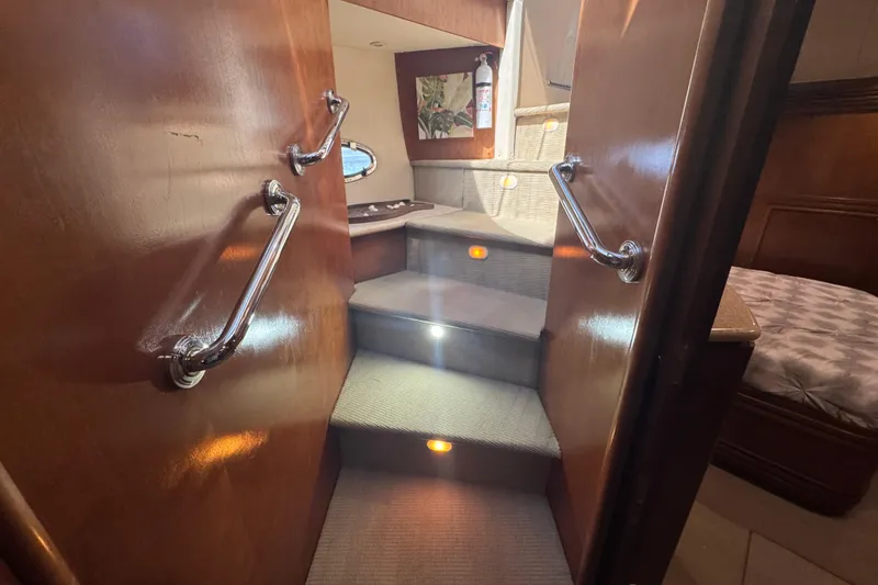 Slide: The Image of Interior stairs of 1998 Carver 530 Voyager Pilothouse with wooden handrails and carpeted steps. - 33