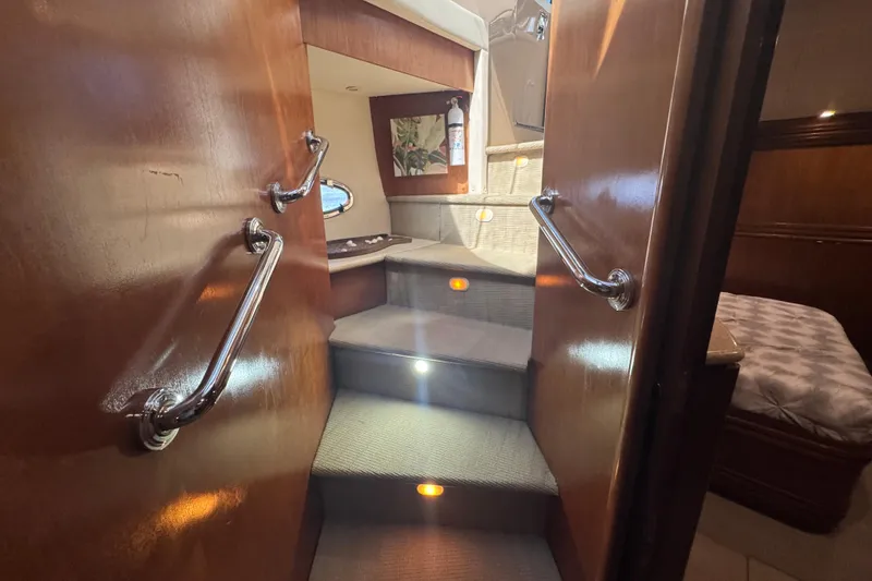 Slide: The Image of Interior stairs of 1998 Carver 530 Voyager Pilothouse with wooden handrails and ambient lighting. - 34