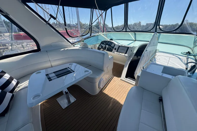 Slide: The Image of 1998 Carver 530 Voyager Pilothouse interior with helm, seating, and table on teak flooring. - 39