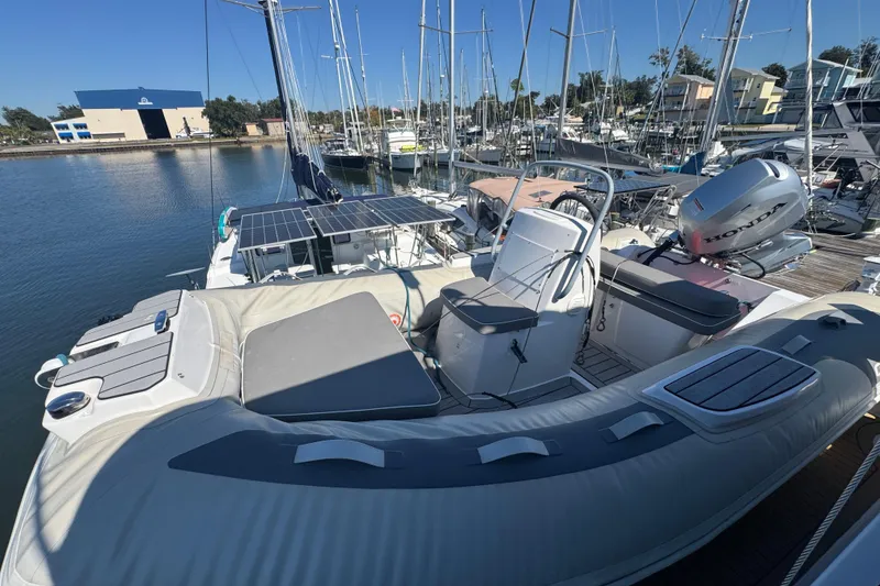 Slide: The Image of 1998 Carver 530 Voyager Pilothouse docked, featuring inflatable boat and Honda outboard motor. - 41