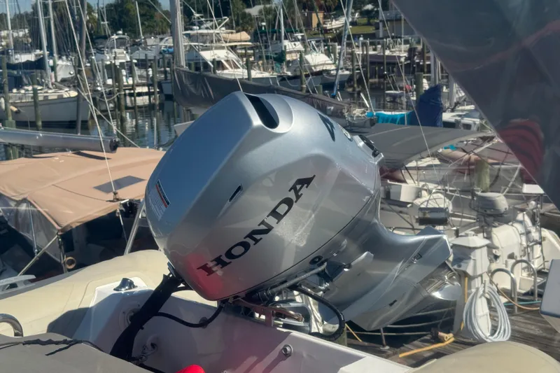 Slide: The Image of Silver Honda outboard motor on a 1998 Carver 530 Voyager Pilothouse, docked at a marina. - 42
