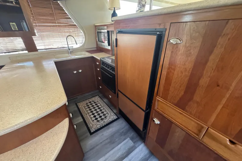 Slide: The Image of 1998 Carver 530 Voyager Pilothouse kitchen with wood cabinetry and modern appliances. - 59