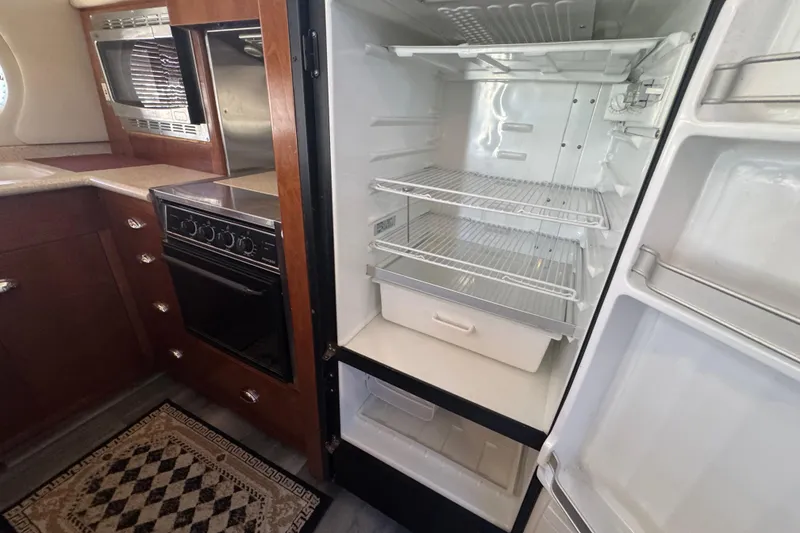 Slide: The Image of Kitchen interior of 1998 Carver 530 Voyager Pilothouse with open fridge and oven. - 61