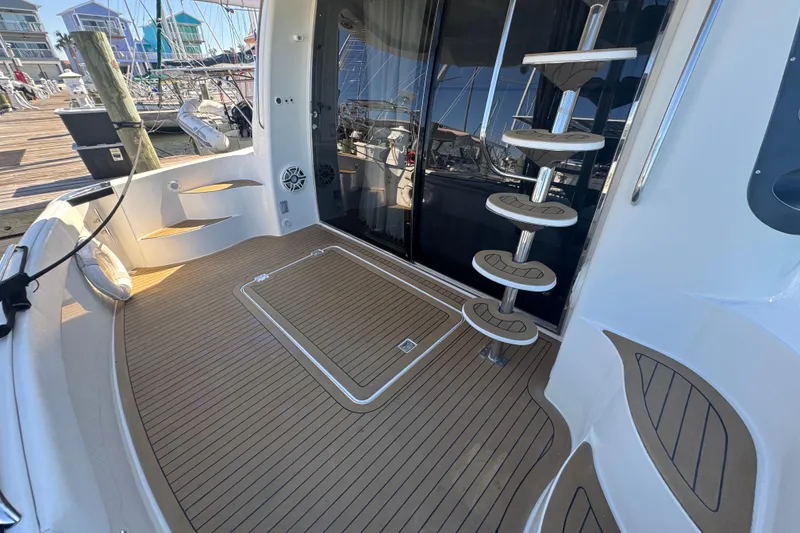 Slide: The Image of 1998 Carver 530 Voyager Pilothouse yacht deck with spiral staircase and marina view. - 75