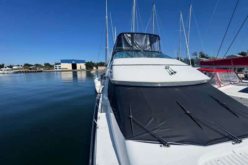 Slide: The Image of 1998 Carver 530 Voyager Pilothouse yacht docked at marina under clear blue sky. - 80
