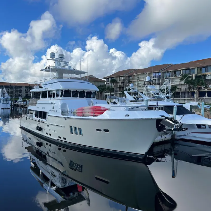 Slide: The Image of Luxurious 2009 Nordhavn N78 yacht docked at marina under blue sky. - 2