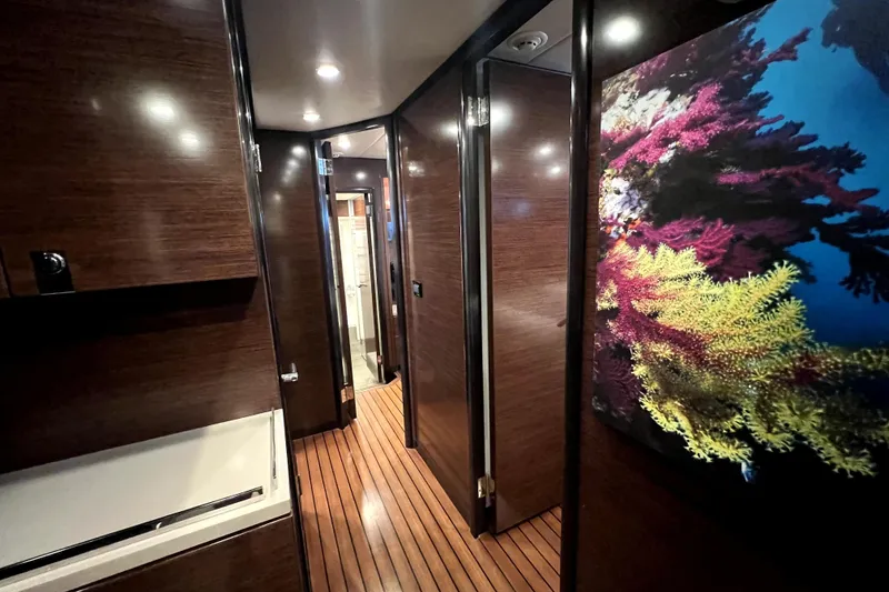Slide: The Image of Luxurious hallway in 2009 Nordhavn N78 yacht with elegant wood paneling and vibrant artwork. - 39