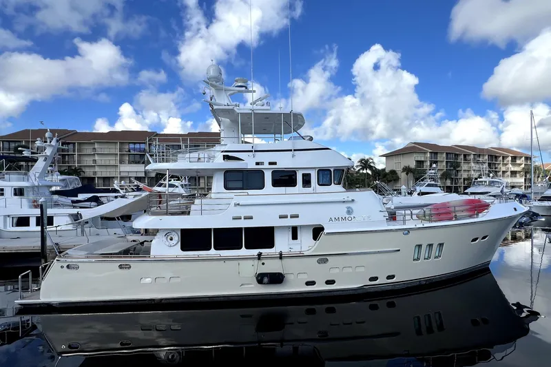 Slide: The Image of Luxurious 2009 Nordhavn N78 yacht docked at marina under blue sky. - 4