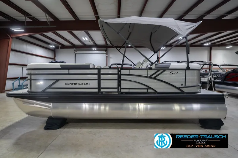 Slide: The Image of 2026 Bennington 20 SSR pontoon boat in showroom with canopy and sleek design. - 11