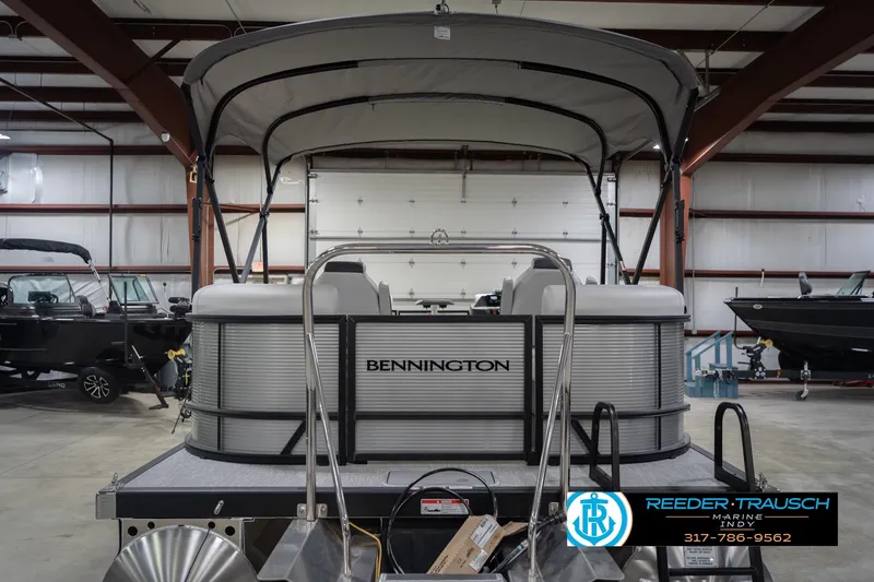Slide: The Image of 2026 Bennington 20 SSR pontoon boat in a showroom with canopy and logo. - 9